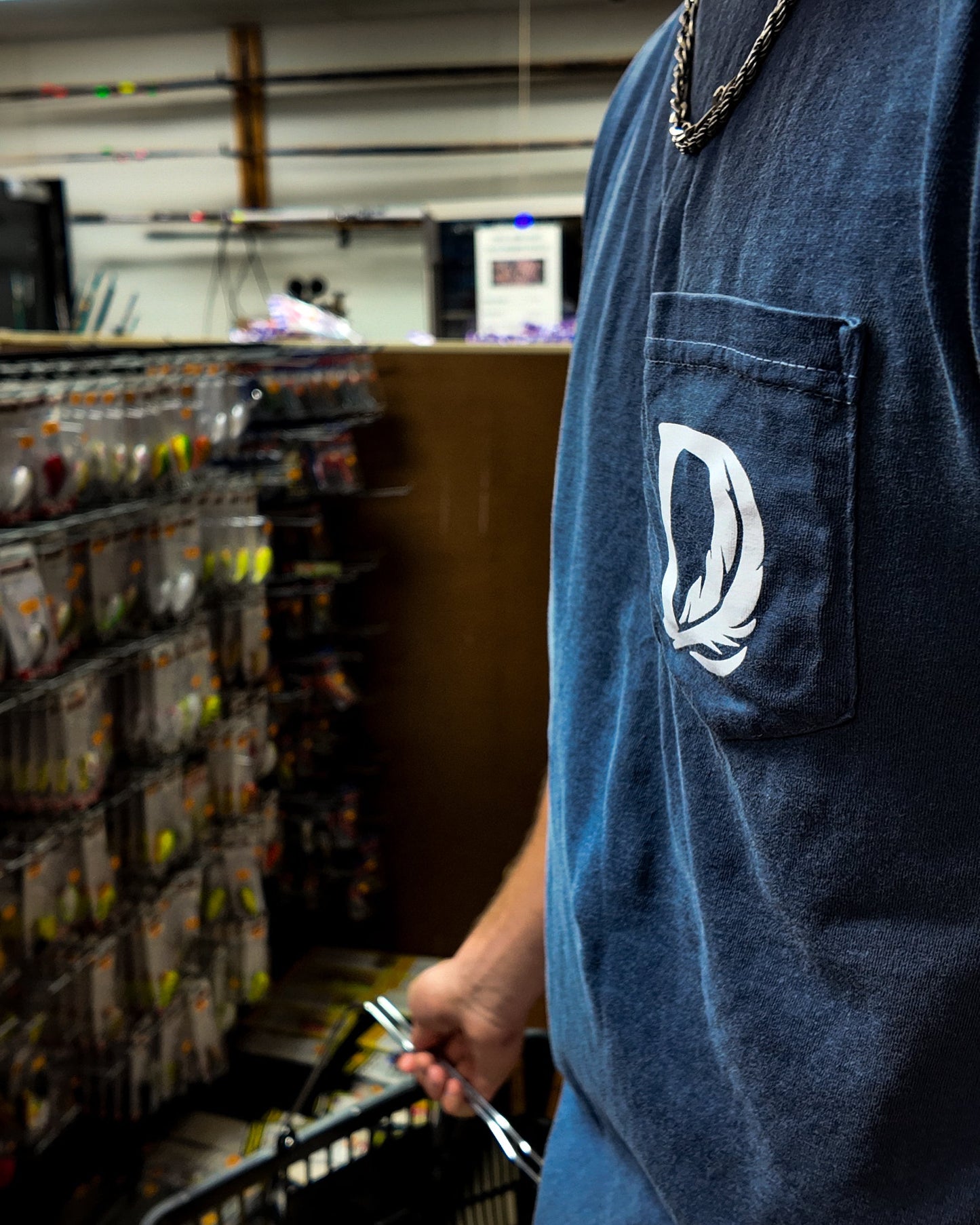 Person shopping in a store aisle with a blue delta feather shirt.