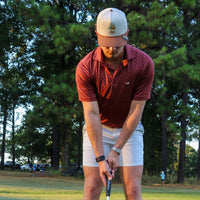 Golfer in the Delta Feather Duck Hook hat standing over a putt on the green