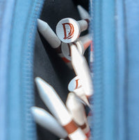 Delta Feather branded golf tees with the D feather mark tucked in a golf bag pocket