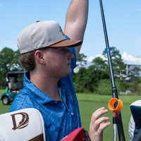 Golfer in the Duck Hook hat pulling a club next to a Delta Feather D headcover