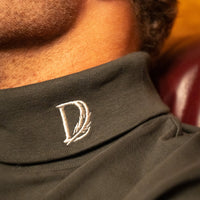 Close-up of the Forest Green Rendezvous Turtleneck collar with Delta Feather logo