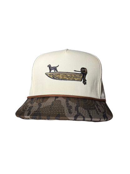 A white cap with bottomland bill with a duck boat on it 