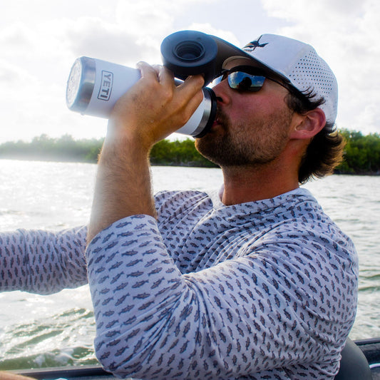 Redfish pattern hoodie being worn on a boat 